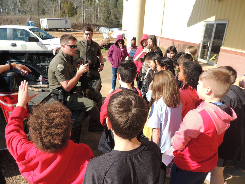 Hunter Hall and Dustin Floyd with the Mississippi Department of Wildlife, Fisheries and Parks teach students about hunting safety.